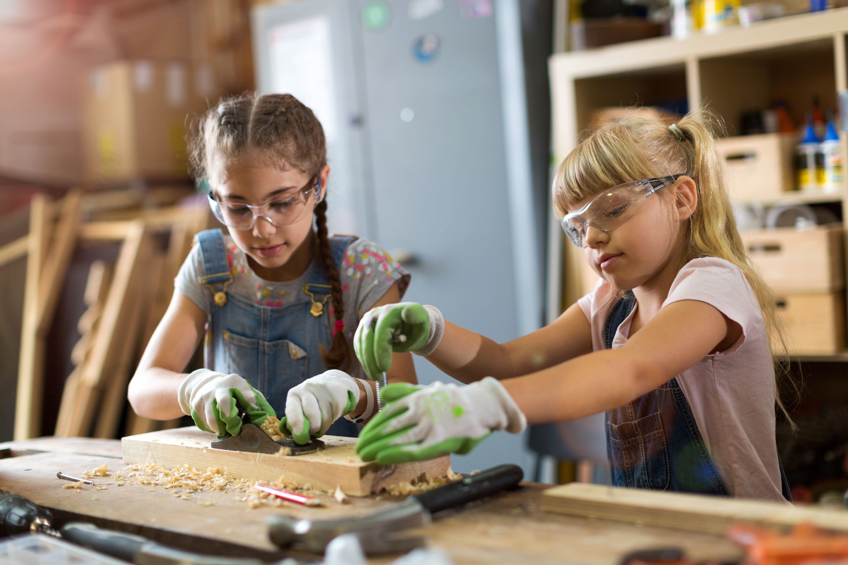 Two young girls in a microschool doing a woodworking project together.